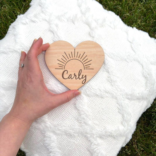 Custom heart-shaped wooden name sign with sunburst design. Perfect for nurseries, newborn gifts, or baby photo props. Personalized for you!